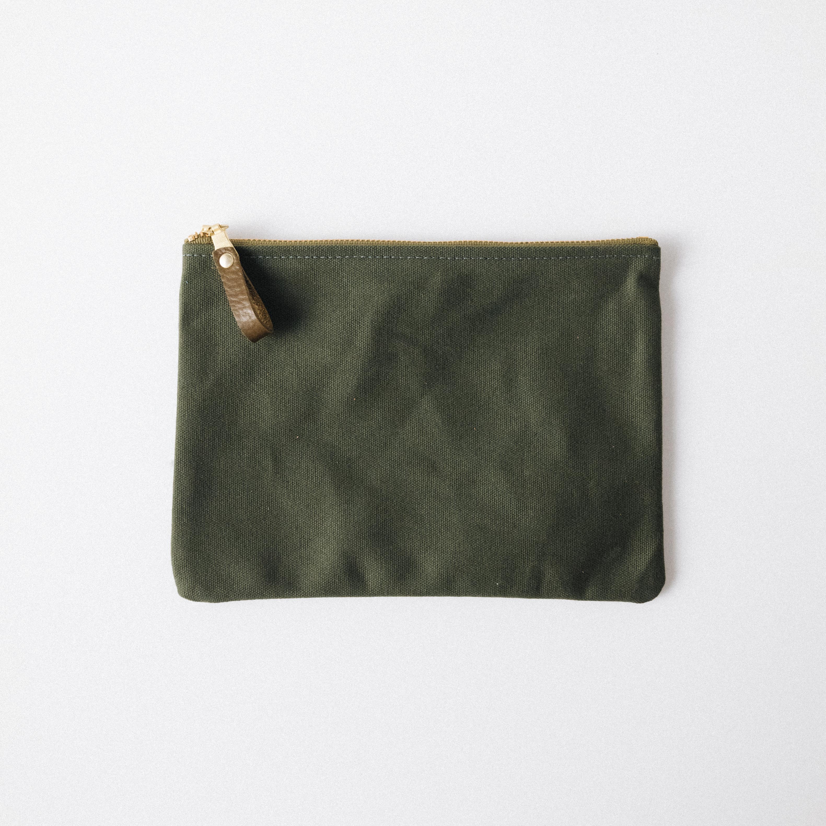 Olive green heavyweight cotton canvas zip pouch with a solid brass zipper and leather pull.