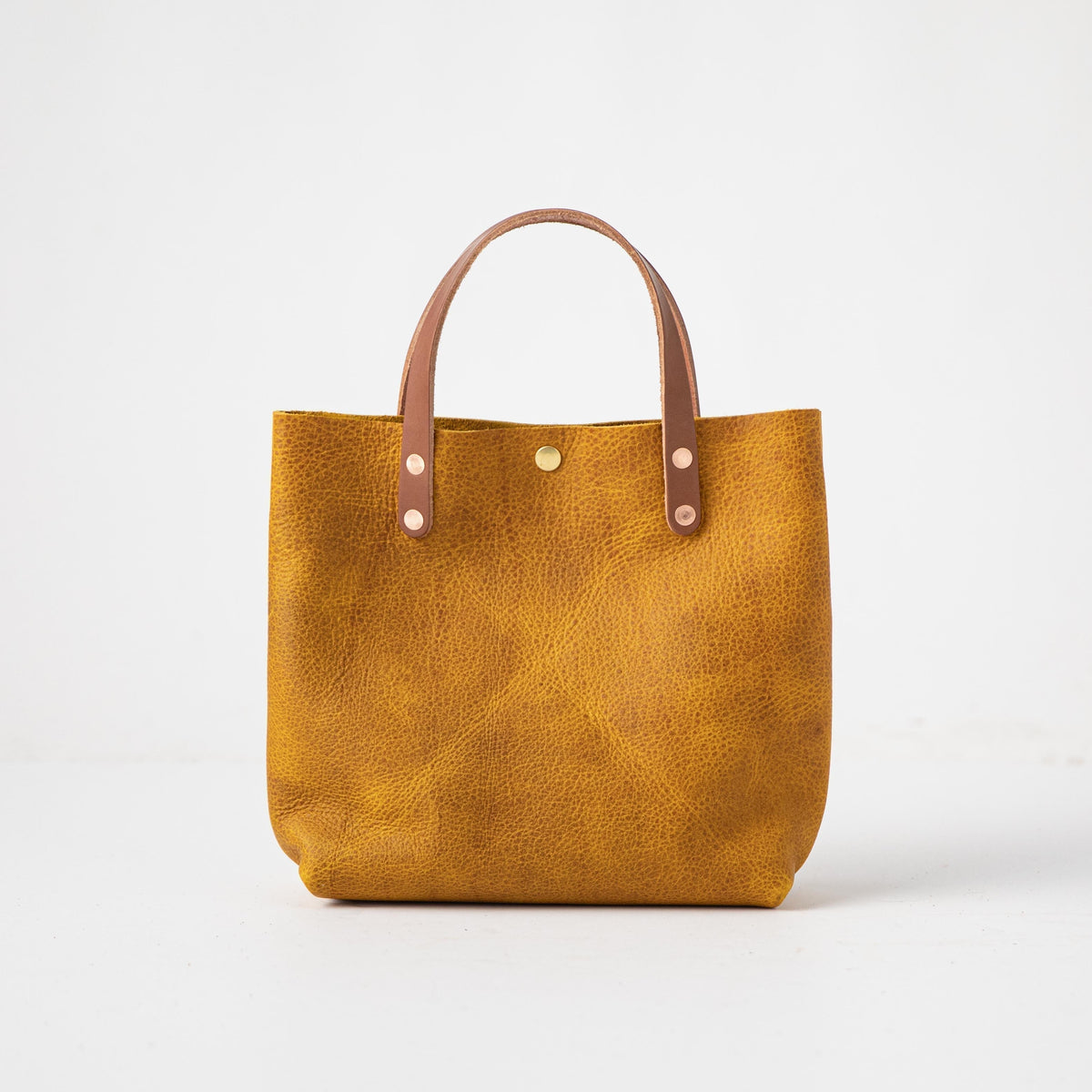 Yellow Bison Mini Tote: vibrant full-grain leather bag with tan handles and heirloom-quality craftsmanship.