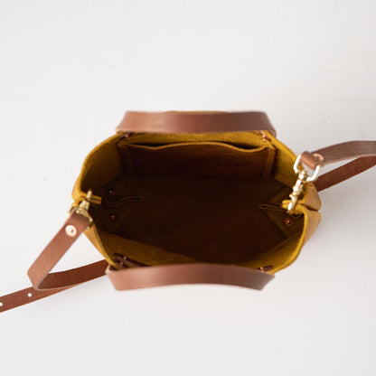 Yellow Bison Mini Tote, a vibrant full-grain leather bag with tan handles and an open top revealing interior pockets.