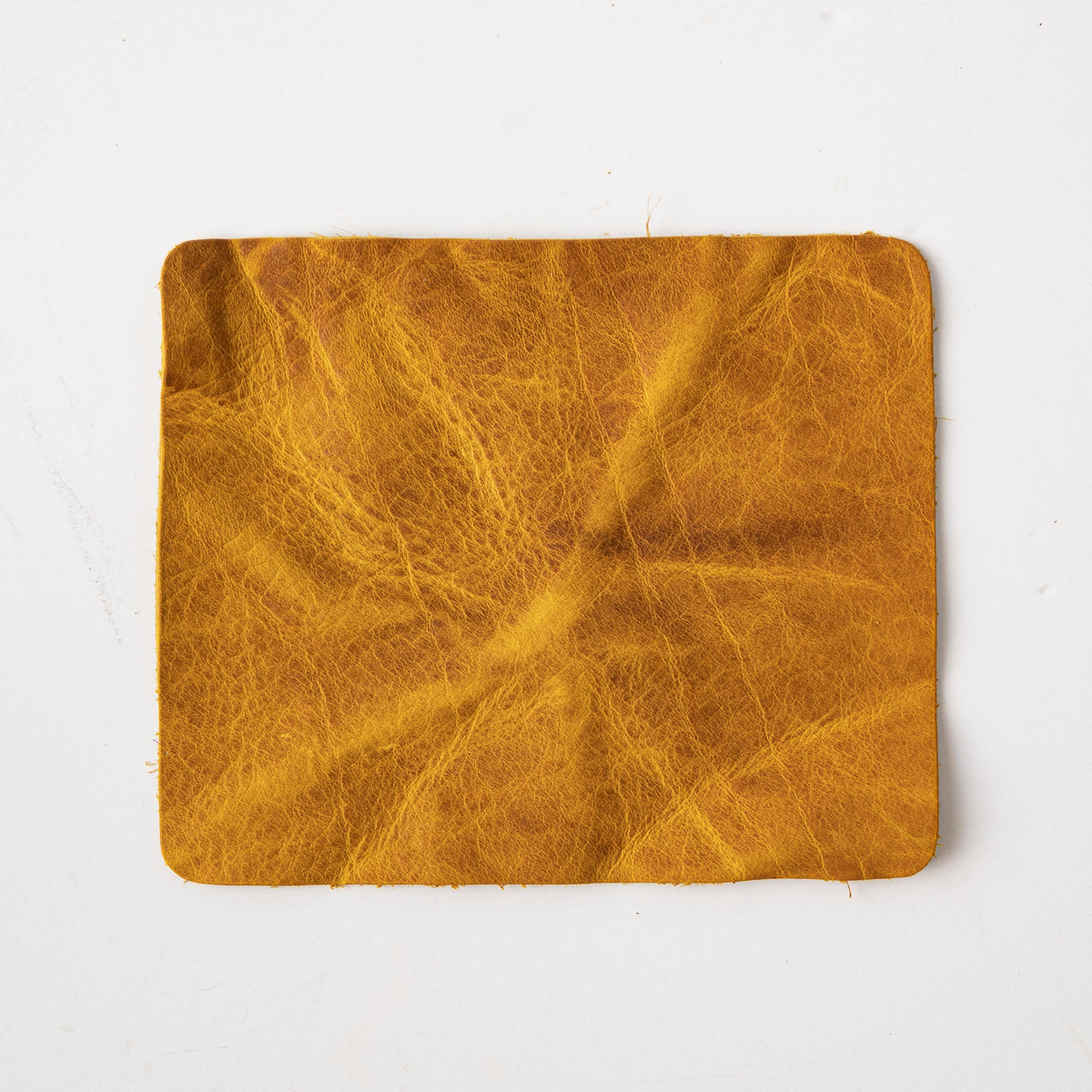 Vibrant Yellow Bison full-grain leather swatch, showcasing its prominent grain and soft temper.