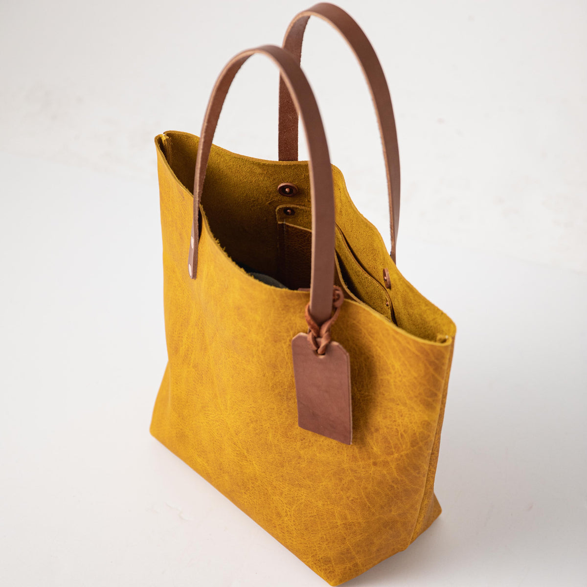 Yellow Bison Tote: vibrant yellow leather, prominent grain, soft temper, tan handles, and a free embossed tag.