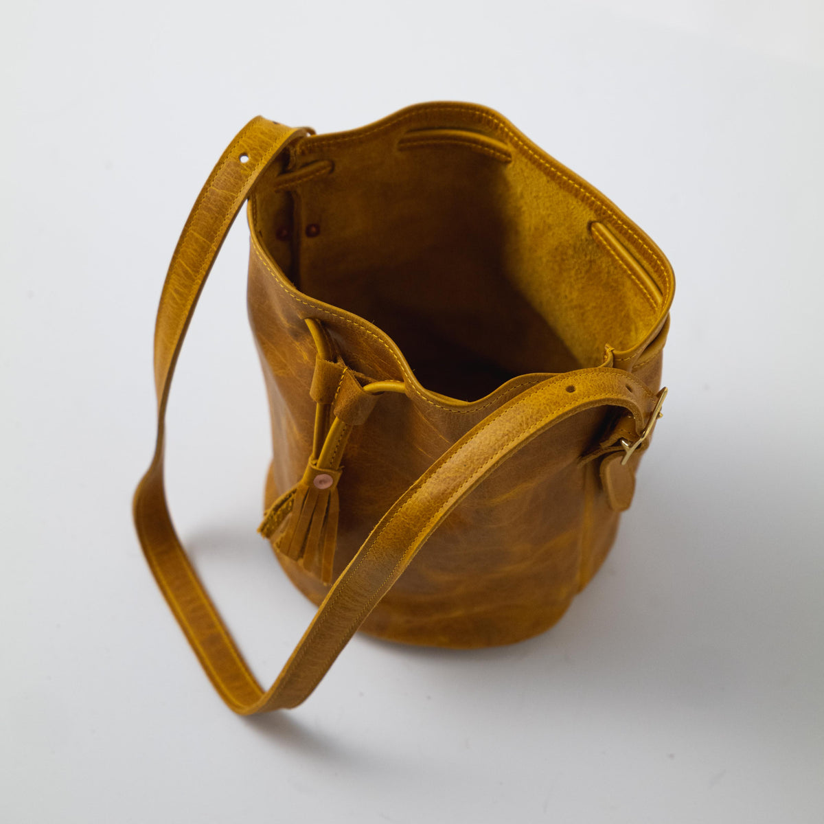 Vibrant Yellow Bison full-grain leather bucket bag with prominent grain, soft temper, and adjustable strap.