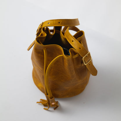 Heirloom-quality Yellow Bison Bucket Bag, handmade of full-grain yellow leather with prominent grain and soft temper.